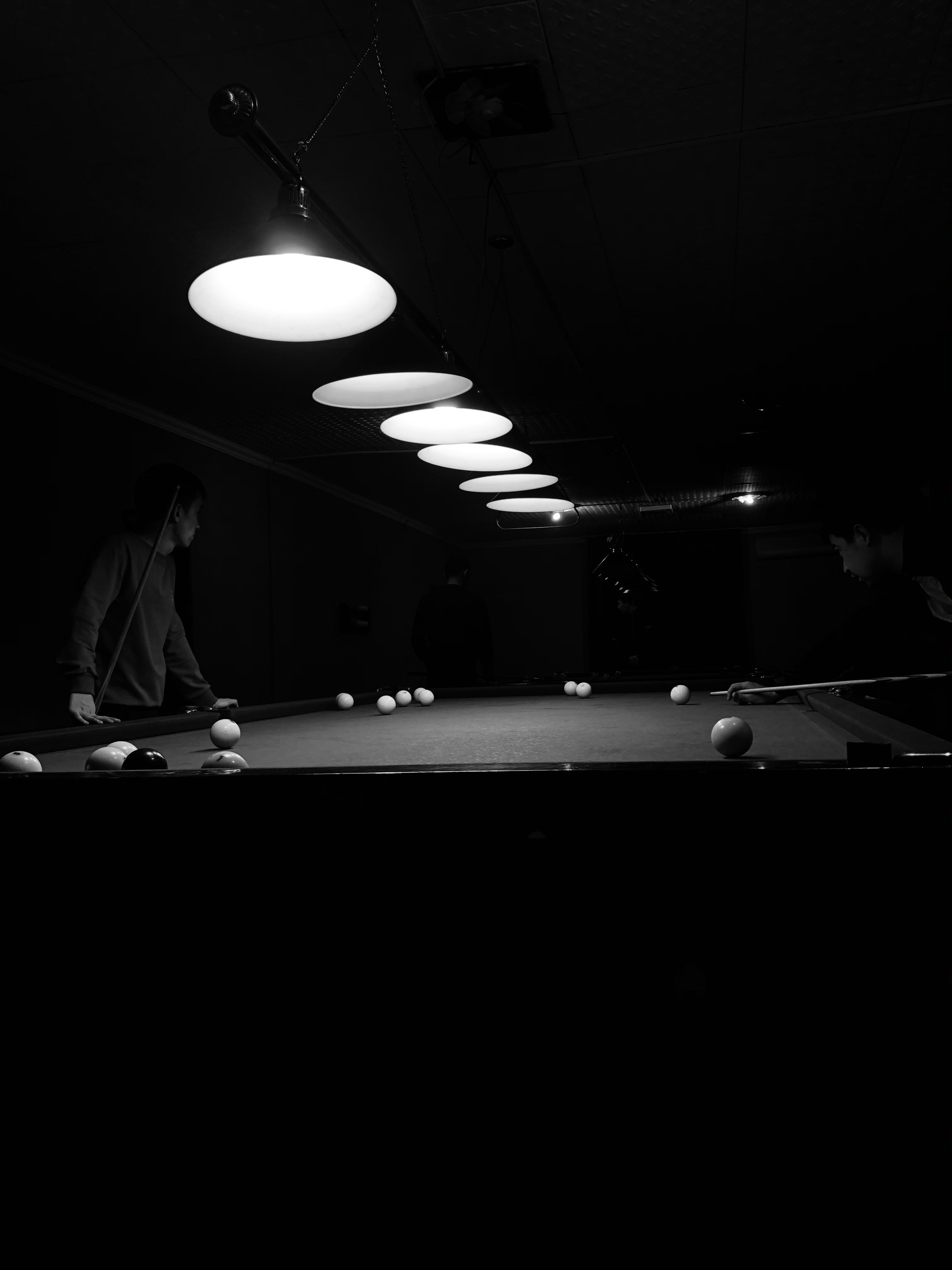 Billiard table with players under lights